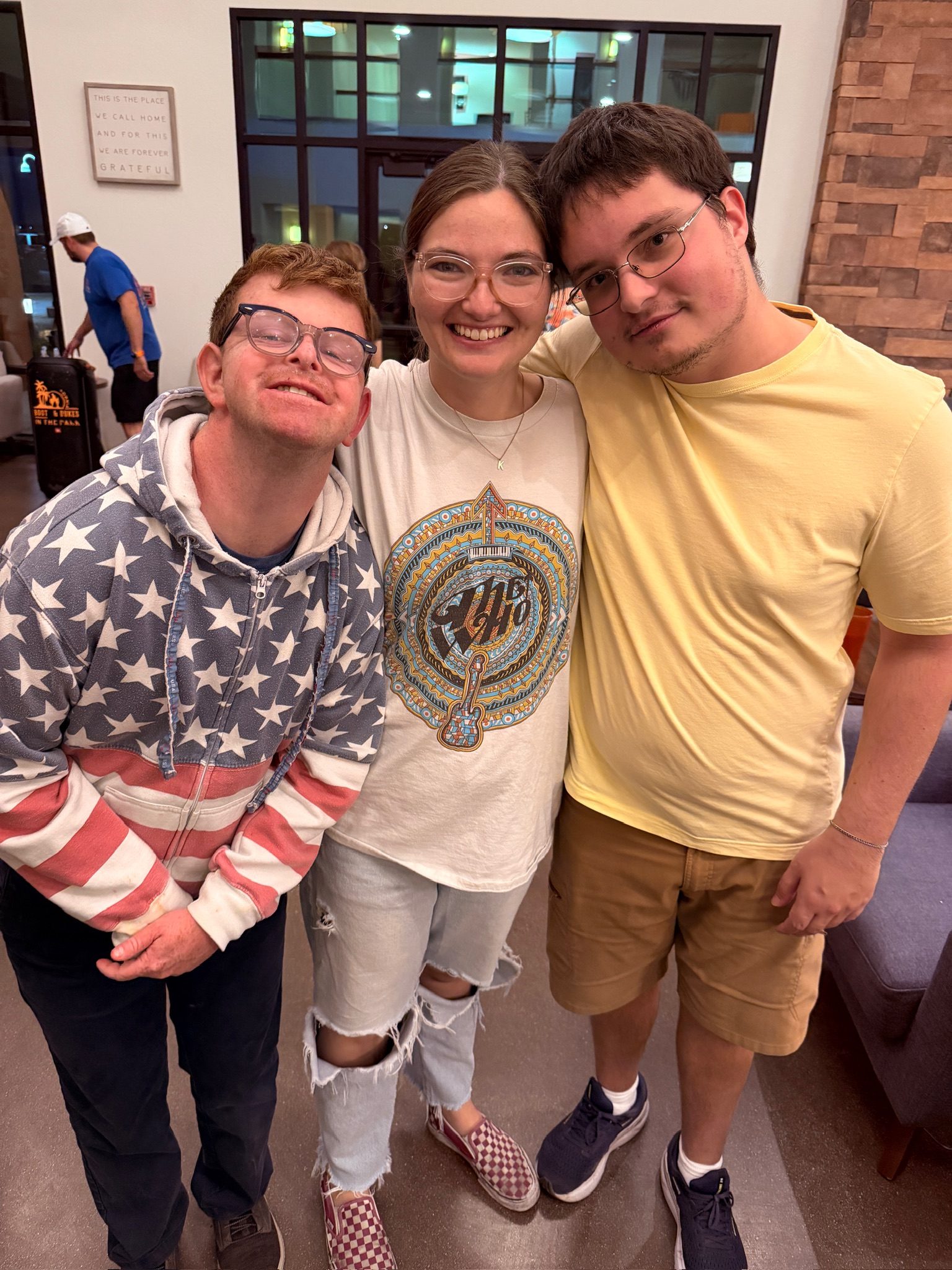 Three Treasure House residents with their arms around each other in the lounge